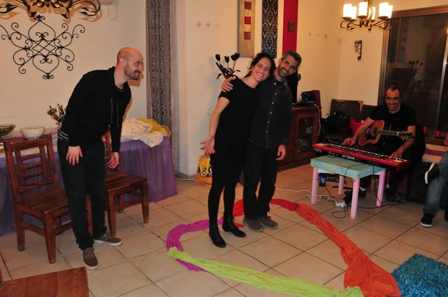 זוג חוגג עם נגן גיטרה ובדים צבעוניים על הרצפה